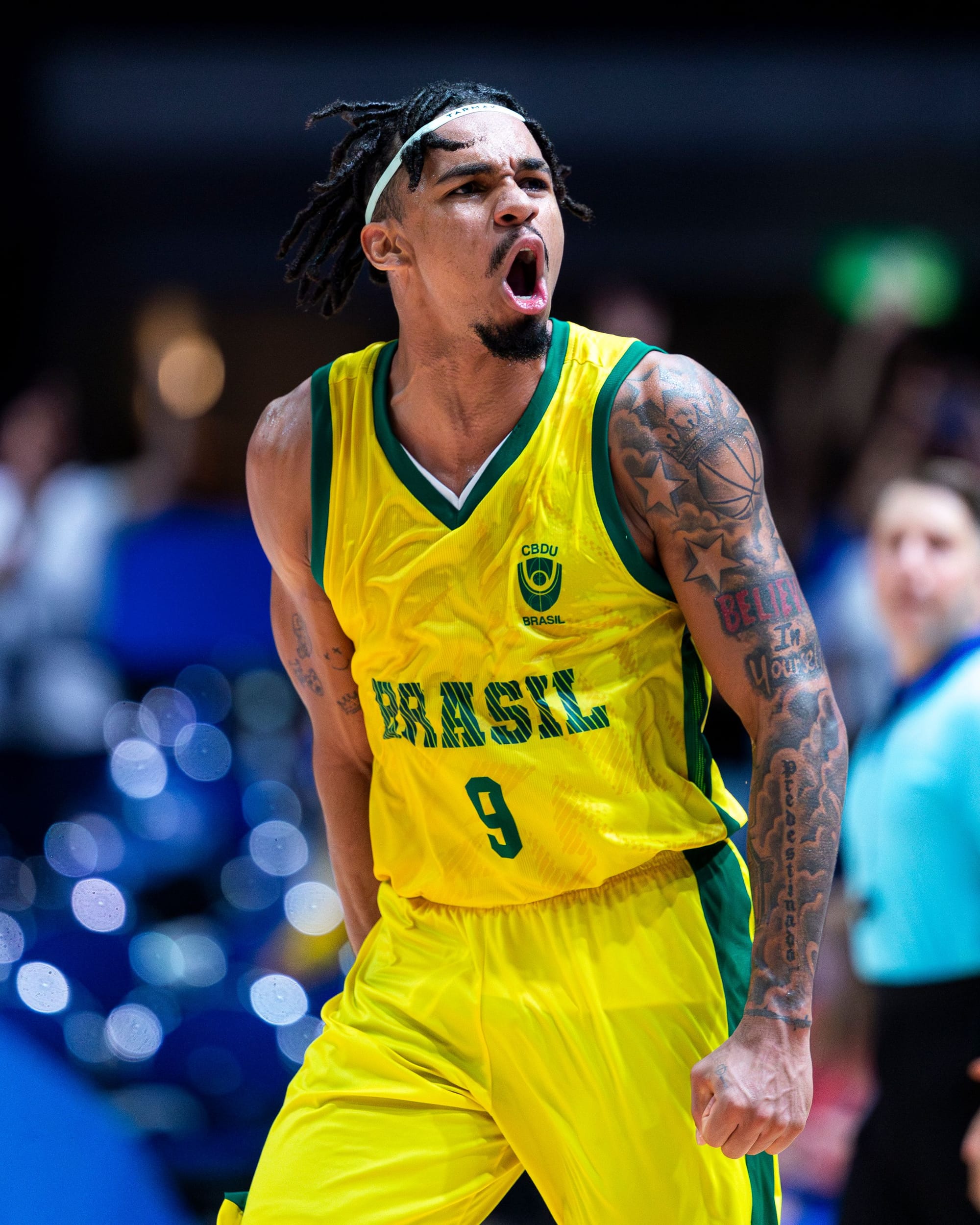 Jogador de basquete com regata amarela vibrando em quadra