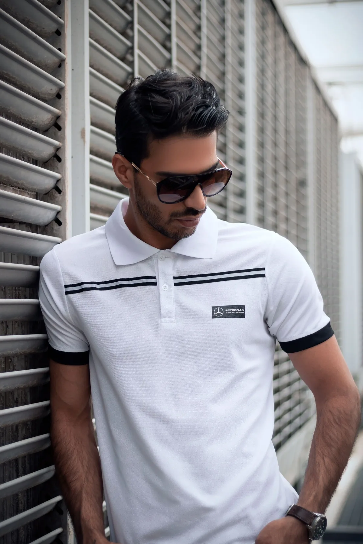 Homem de óculos escuros vestindo polo branca personalizada com detalhes em preto