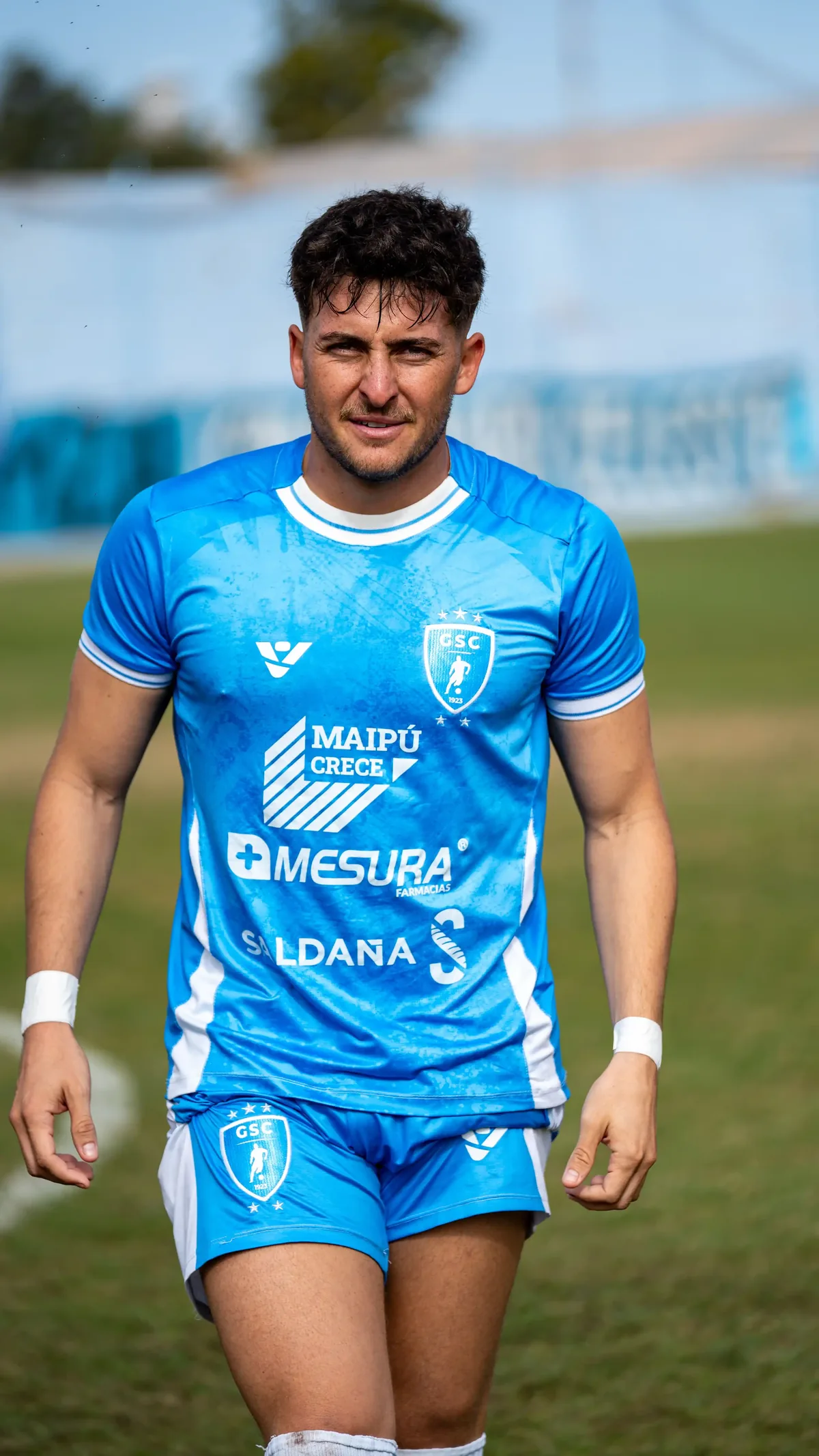 Jogador de futebol com uniforme azul personalizado, camisa e shorts do mesmo kit